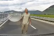 Người đàn ông cầm đá chặn ô tô trên đường bộ cao tốc 