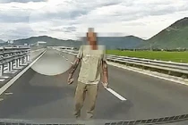 Người đàn ông cầm đá chặn ô tô trên đường bộ cao tốc 