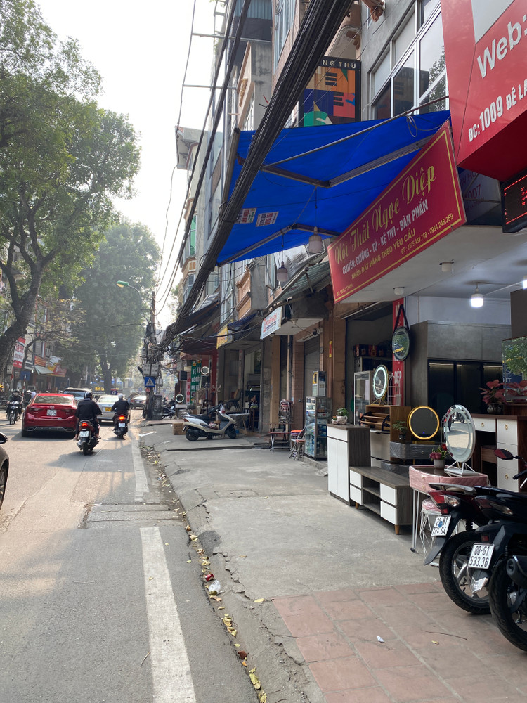 Trước đây, vỉa hè đường Đê La Thành mặc nhiên trở thành nơi bày bán hàng hóa của các hộ kinh doanh, người dân buộc phải đi bộ dưới lòng đường - Ảnh: T.Huy