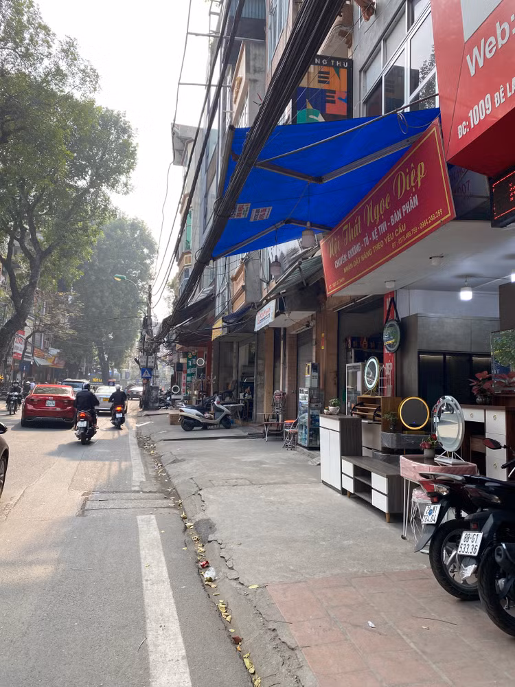 Trước đây, vỉa hè đường Đê La Thành mặc nhiên trở thành nơi bày bán hàng hóa của các hộ kinh doanh, người dân buộc phải đi bộ dưới lòng đường - Ảnh: T.Huy