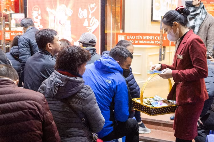 Nhân viên cửa hàng hướng dẫn khách xếp thành hàng ngay ngắn và phát phiếu mua hàng - Ảnh:phunuvietnam