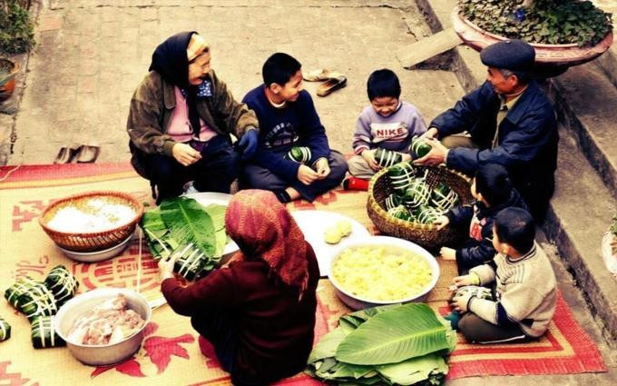 Cả gia đình quây quần ngồi gói bánh chưng.