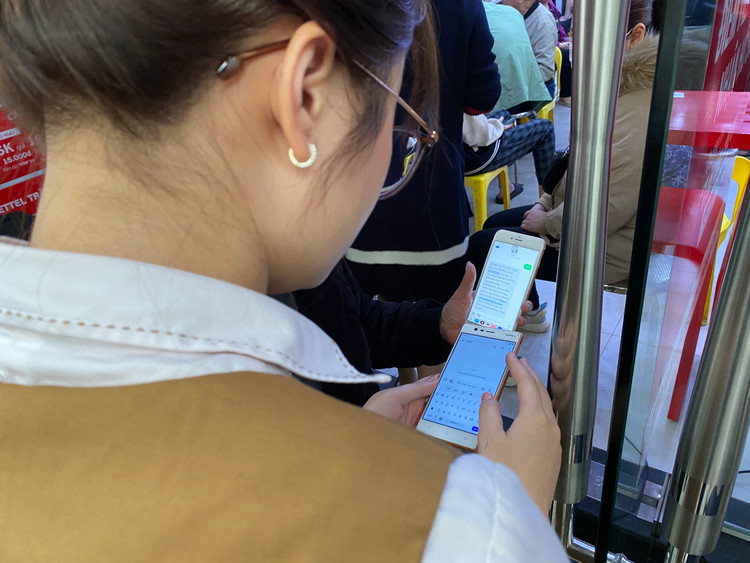 Nhân viên cửa hàng đang hướng dẫn người dân soạn cú pháp trên điện thoại di động để kiểm tra thuê bao di động của mình đã đầy đủ thông tin hay chưa. Việc kiểm tra trước sẽ tiết kiệm thời gian chờ đợi cho người dân. Để tra cứu thuê bao có thuộc tập phải Chuẩn hóa thông tin theo Nghị định 49 không, khách hàng có thể soạn tin nhắn TTTB gửi 1414.