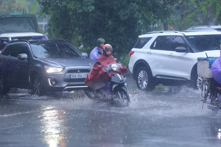 Trưa ngày 12/6, trận mưa lớn xối xả, kèm dông, lốc, sấm sét đã khiến nhiều tuyến phố thuộc khu vực nội thành Hà Nội đã rơi vào ngập cục bộ, nhiều người phải dắt xe vượt qua các khu vực bị ngập.