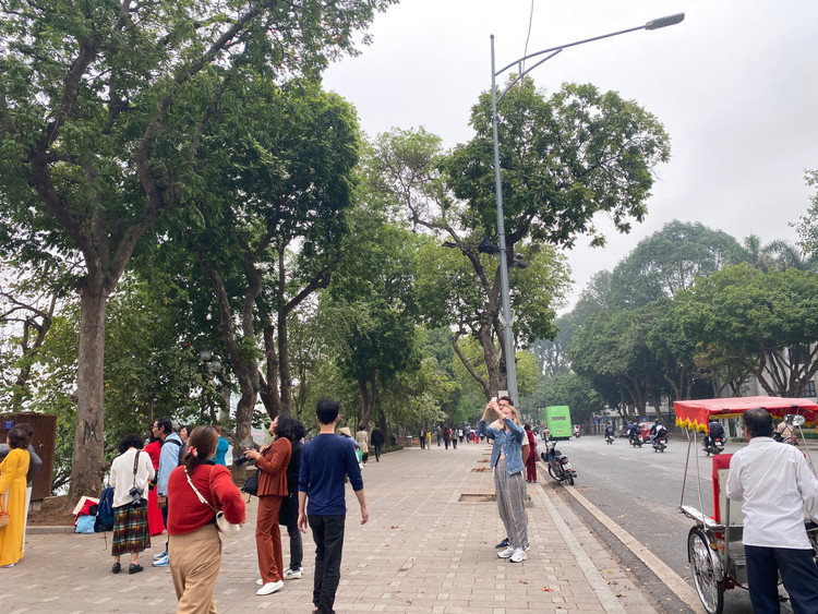 Không chỉ người dân Việt Nam, nhiều du khách nước ngoài cũng tỏ ra rất thích thú với sắc đỏ tươi thắm của hoa gạo.- Ảnh:T.Huy