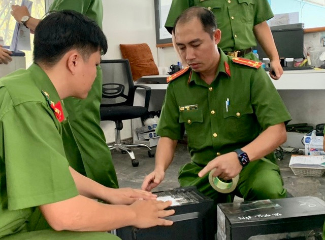 Công an khám xét Trung tâm đăng kiểm xe cơ giới 61-09D Ảnh: TNO