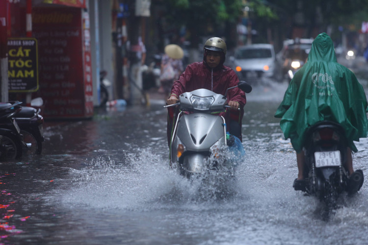 Nước bắn tung toé khi chiếc xe này vặn mạnh tay ga vượt qua dòng nước ngập.