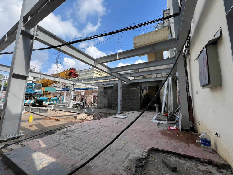 Công trình được đào móng, đổ trụ cột bê tông mới và lắp đặt khung dầm thép tầng một. Phần tường nhà ở một vị trí cũng được xây mới.