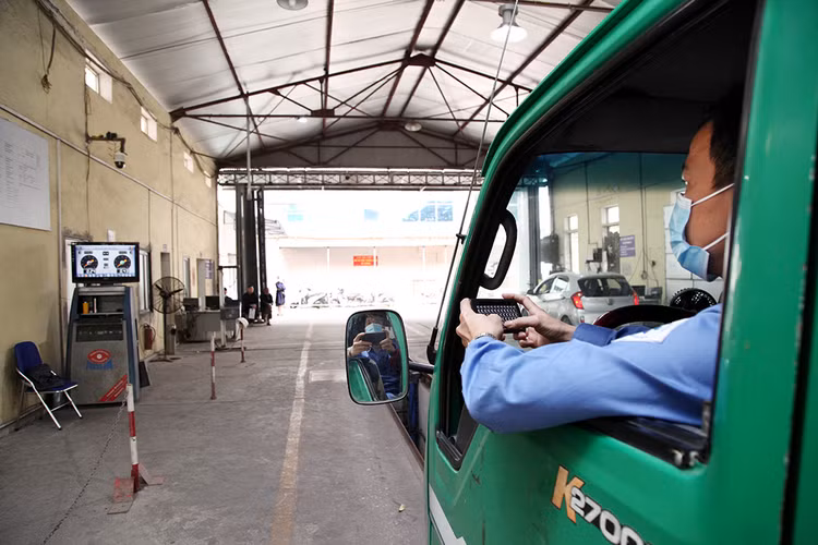 Kỹ thuật viên của trung tâm đăng kiểm đang kiểm tra hệ thống phanh của xe.