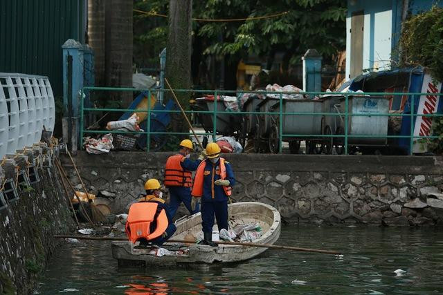 Công nhân vớt cá chết tại hồ Tây. Ảnh: Quỳnh Mai