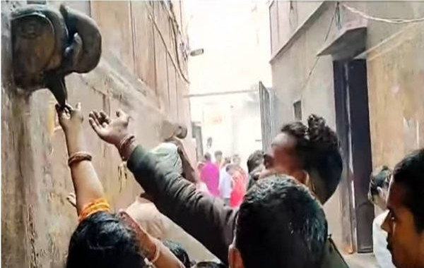 Nhiều người cố hứng lấy &quot;nước thánh&quot; rỉ ra từ miệng tượng voi treo tường.