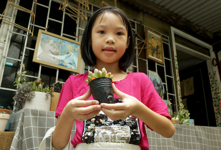 Bé Vũ Hà Mi lớp 3C trường Tiểu học Đồng Tâm đang vui mừng khi chọn được cây sen đá, bé nói bé sẽ tưới cây hàng ngày.