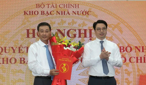 Tổng Giám đốc Kho bạc Nhà nước Trần Quân trao quyết định cho ông Lê Thanh Phương (bên trái). Ảnh: Sài Gòn Giải phóng.