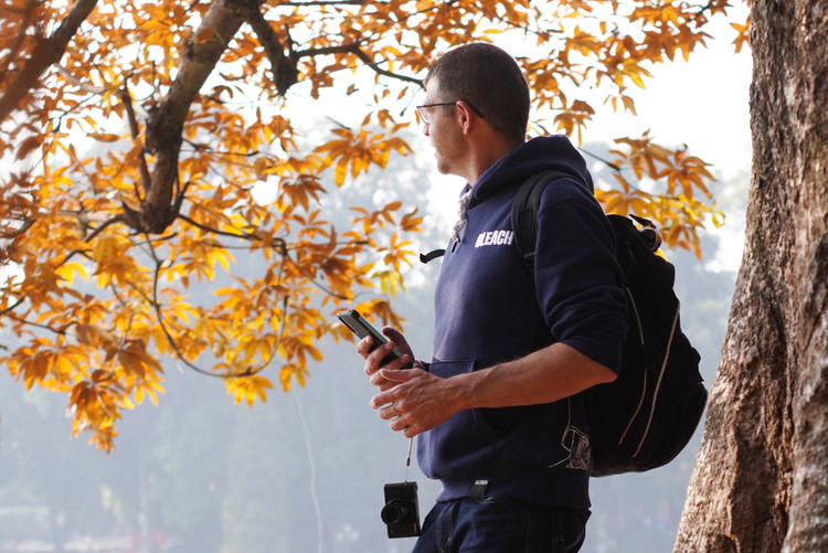 Một du khách nước ngoài tỏ ra rất thích khi được chiêm ngưỡng sắc lá vàng tại Việt Nam.