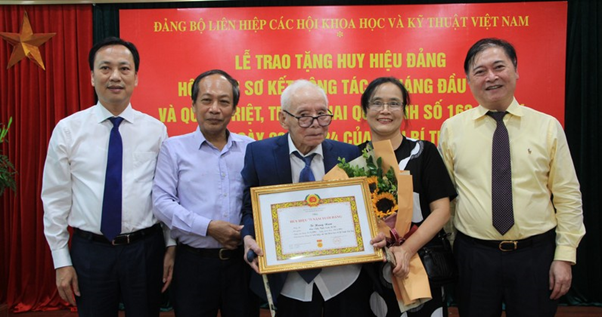 Ông Lại Xuân Lâm (bên trái) và TSKH Phan Xuân Dũng (bên phải) trao Huy hiệu 75 tuổi Đảng cho ông Tô Hưng Nam.