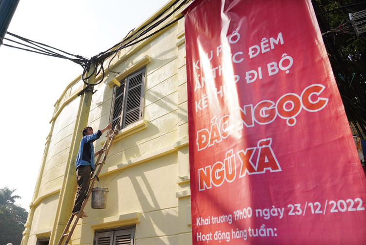 Một người dân đang sơn lại bên ngoài ngôi nhà của mình.