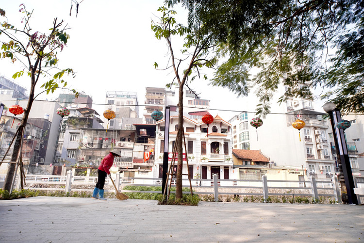 Công nhân đang quét dọn sạch bụi bẩn trên vỉa hè phố Trúc Bạch.