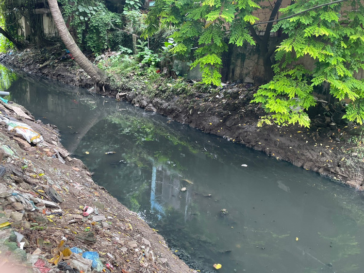 Nằm ngay mặt bờ mương là trường Tiểu học Vạn Phúc - Ba Đình. Mặc dù trước cổng trường có hàng rào tôn che chắn, không nhìn thấy dòng nước đen kịt, theo làn gió, mùi hôi thối vẫn bốc lên nồng nặc.