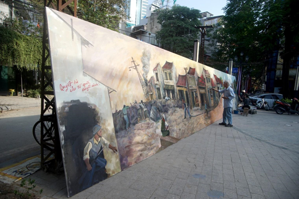 Bức tranh Panorama được triển lãm từ ngày 5/10 tại Khu phố ẩm thực đêm Đảo Ngọc Ngũ Xã. Hoạ sĩ. NSND Nguyễn Dân Quốc, 82 tuổi, nhà ở 33 phố Lãn Ông cho biết: “Với mong muốn cho lớp trẻ cũng như người Hà Nội ngày hôm nay hiểu thêm về lịch sử. Trong bức tranh có 3 giai đoạn, giai đoạn đầu tiên vào năm 1946, các chiến sĩ cảm tử ôm bom ba càng tấn công xe tăng, giai đoạn thứ 2 nói về thời kì bao cấp sau chiến tranh và giai đoạn thứ 3 về sự phát triển của Hà Nội hôm nay”.