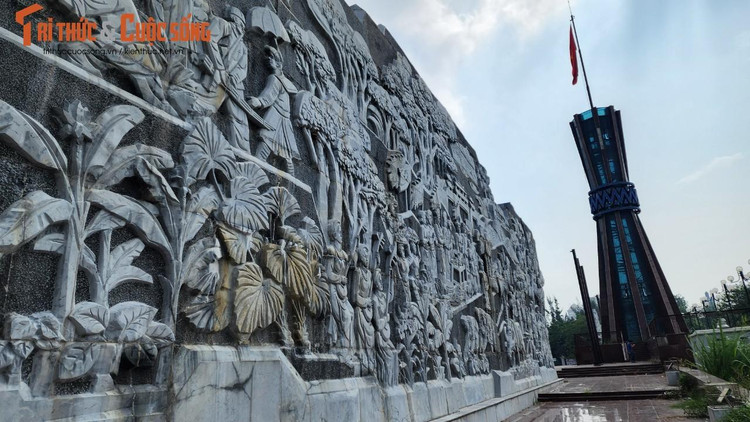 Bức phù điêu bị úa màu, nham nhở vết nứt, rêu cỏ.