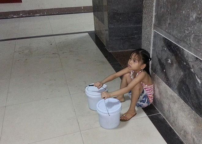 Hình ảnh em bé 7 tuổi phải đi xách nước vì bố vắng nhà, mẹ vừa sinh em bé được netizen chia sẻ trên nhiều hội nhóm.