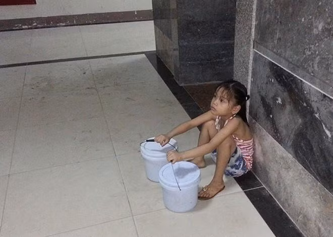 Hình ảnh em bé 7 tuổi phải đi xách nước vì bố vắng nhà, mẹ vừa sinh em bé được netizen chia sẻ trên nhiều hội nhóm.