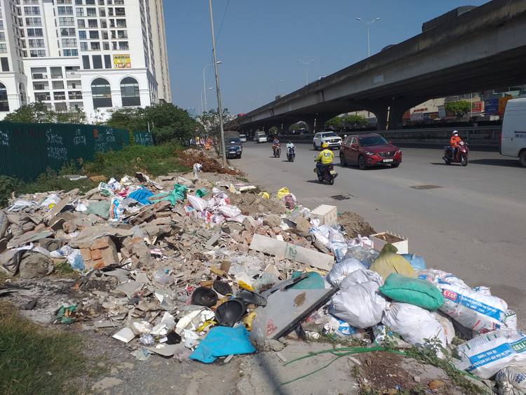 Rác, phế thải còn tràn cả xuống lòng đường Nguyễn Xiển...