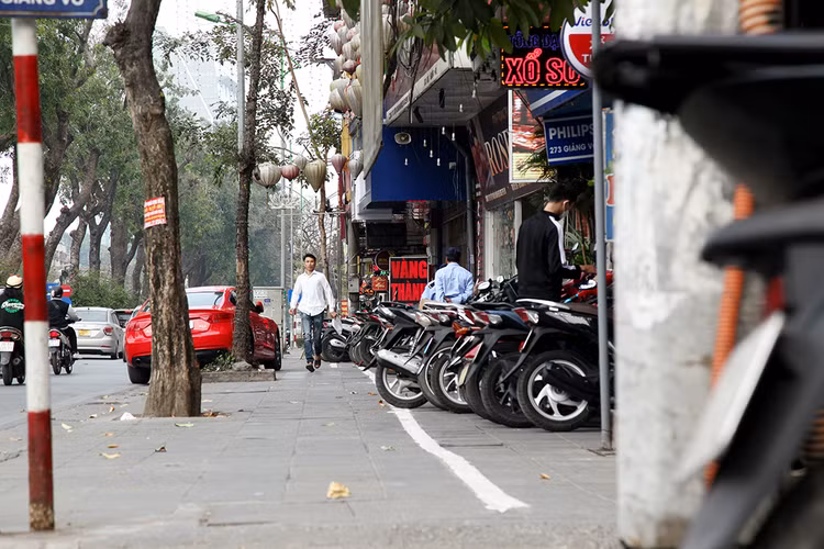 Trên phố Giảng Võ, những vạch sơn trắng chỉ giới chỗ để xe cho thấy các hộ kinh doanh chấp hành nghiêm chỉnh việc không lấn chiếm vỉa hè.