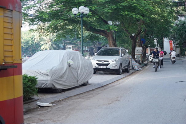 Những chiếc ô tô trùm bạt ngày đêm để trên vỉa hè vừa mới được lát xong.