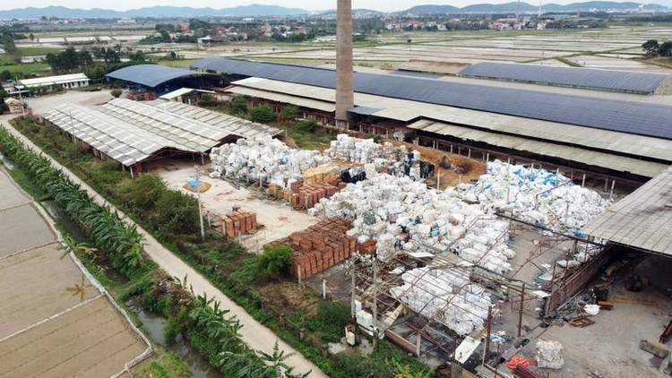 Các kiện bao bì cũ phế liệu được chất đống cao, nằm ngổn ngang xen lẫn một vài đống gạch trong khuôn viên nhà máy gạch tuynel của Công ty Cổ phần Xây dựng và Thương mại QC.