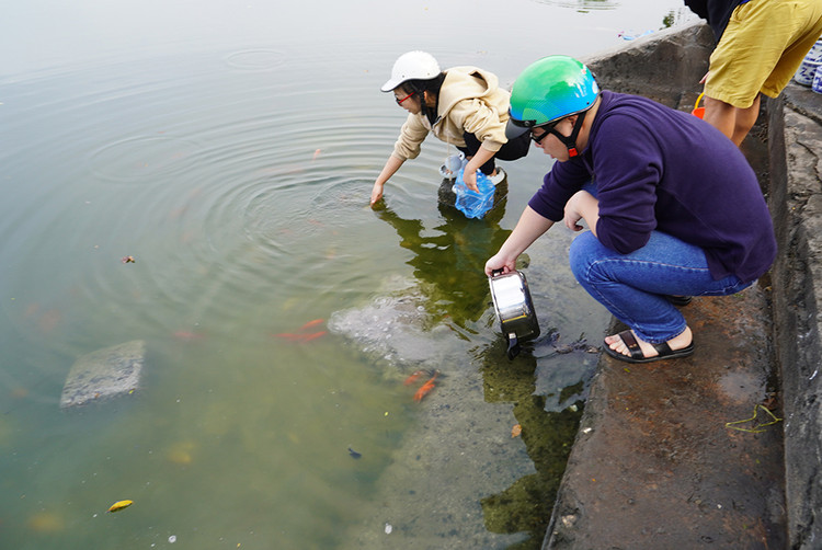 Tuy nhiên, tại khu vực thả cá có rất nhiều tro nổi lên mỗi khi người dân thả cá xuống.