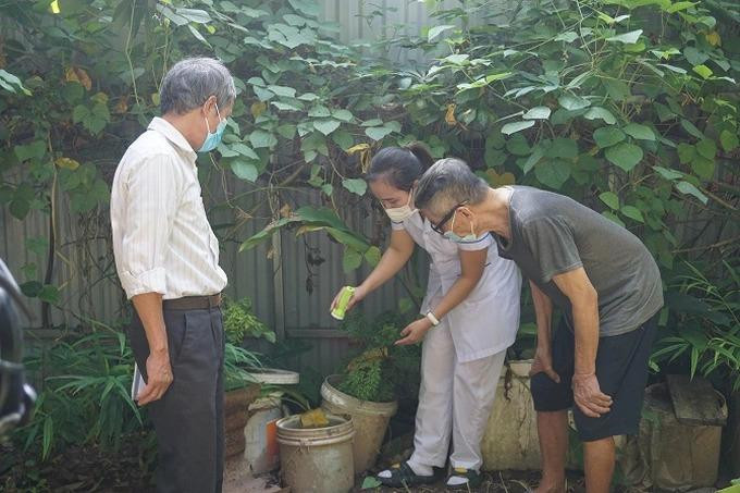 Cán bộ TYT xã Tân Lập đang hướng dẫn người dân lật úp, che đậy các dụng cụ chứa nước không cho muỗi sinh sản và phát triển để phòng, chống sốt xuất huyết (Ảnh: Sở Y tế).