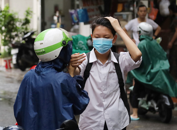 Chị Hiền truyền niềm tin cho con trai bằng cái nắm chặt và hôn vội vào tay con.