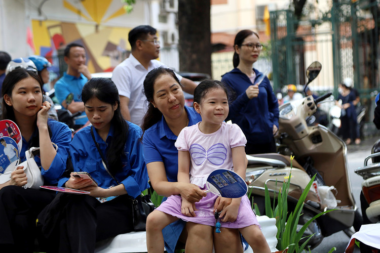 Sự vô tư của bé gái Võ Nguyễn Ngọc An cùng mẹ đợi anh đang thi trước cổng trường THPT Trần Phú có thể giúp giảm áp lực cho mỗi kỳ thi.