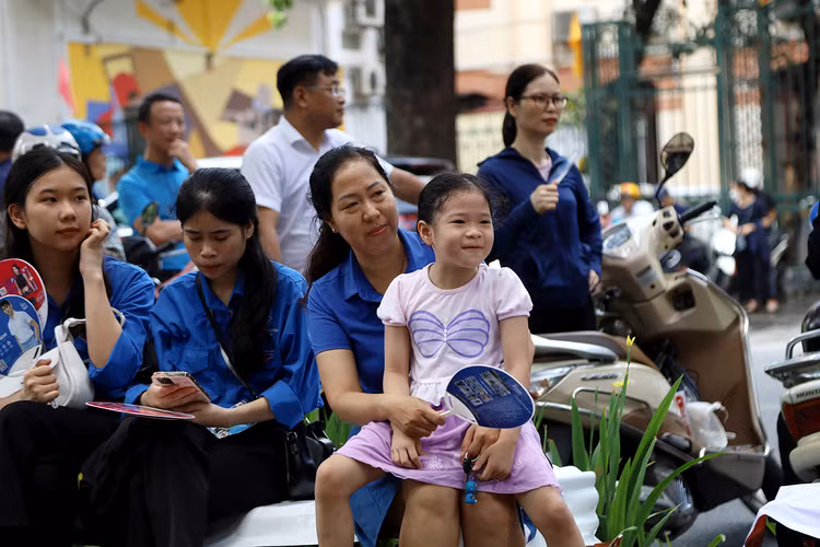 Sự vô tư của bé gái Võ Nguyễn Ngọc An cùng mẹ đợi anh đang thi trước cổng trường THPT Trần Phú có thể giúp giảm áp lực cho mỗi kỳ thi.