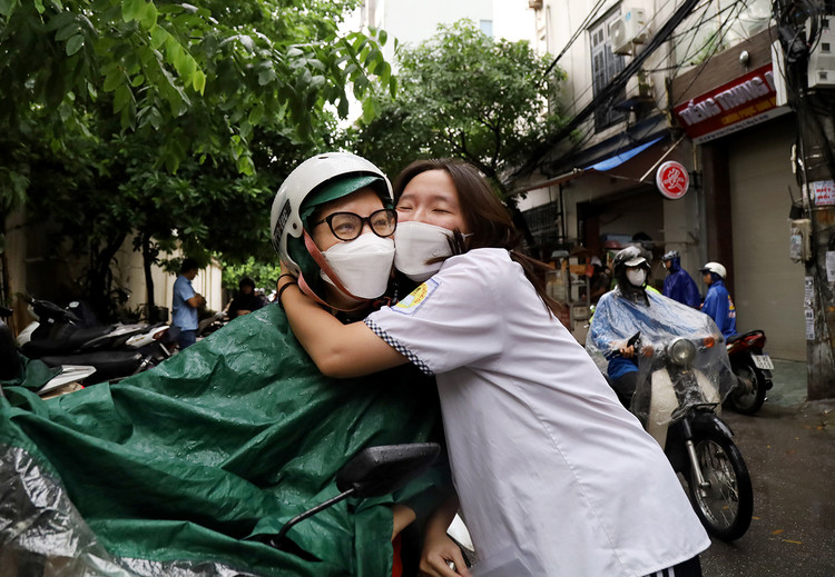 Dưới cơn mưa bất chợt buổi sáng ngày 28/6, để tiếp thêm động lực cho con trước khi thi, gò má của chị Hồng Trang chạm vào má con gái Minh Phương (12D3 THPT Thái Thịnh, Đống Đa).