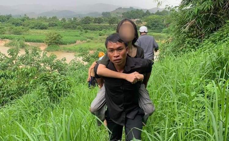 Bé gái 11 tuổi được các cán bộ và người dân cứu.