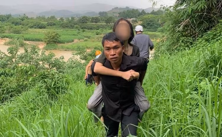 Bé gái 11 tuổi được các cán bộ và người dân cứu.