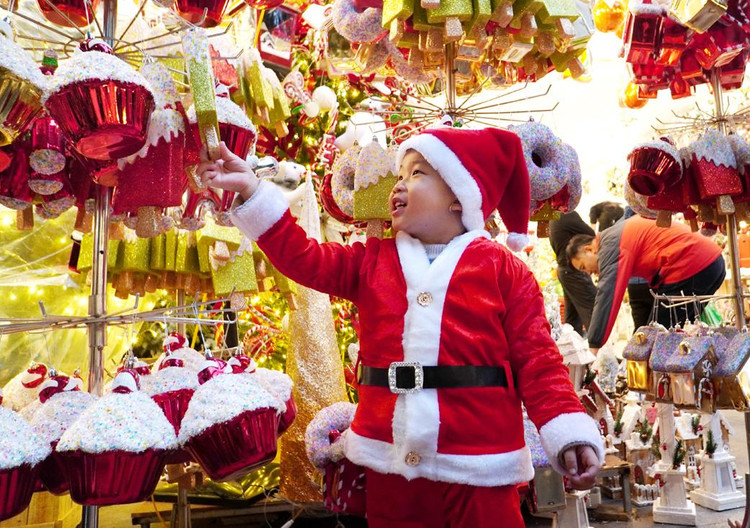 Bé Chuối, Đặng Minh Quân, 3 tuổi rất thích thú với những món đồ chơi tại phố Hàng Mã (Hoàn Kiếm, Hà Nội).