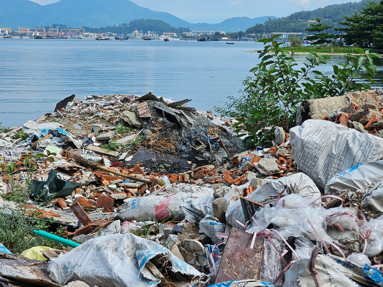 Theo ghi nhận của phóng viên Khoa học và Đời sống/Báo Tri thức và Cuộc sống sáng 25/6, khu vực vịnh Mân Quang, thuộc quận Sơn Trà, TP Đà Nẵng, nhếch nhác, ô nhiễm với đủ loại rác thải. Xà bần, phế liệu... được chất cao &quot;có ngọn&quot; trên bờ ngay sát mặt nước.