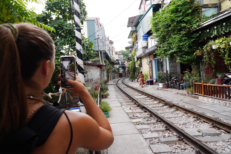 Hai du khách người Hy Lạp đứng bên ngoài ghi lại hình ảnh khu hàng quán đang bị đóng cửa.