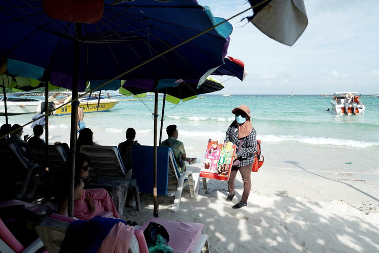 Nhiều người bán hàng rong mời chào khách mua quà lưu niệm trên bãi tắm.