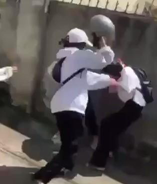 Nhóm nữ sinh dùng mũ bảo hiểm đánh bạn tới tấp. (Ảnh cắt từ clip).