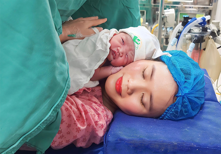 Thời khắc bé gái Lê Dương Vy Anh, nặng 2800g, con của sản phụ Lê Thị Hoa ở Sóc Sơn, Hà Nội cất tiếng khóc chào đời bằng phương pháp mổ đẻ. Ảnh Bệnh viện Phụ Sản Hà Nội