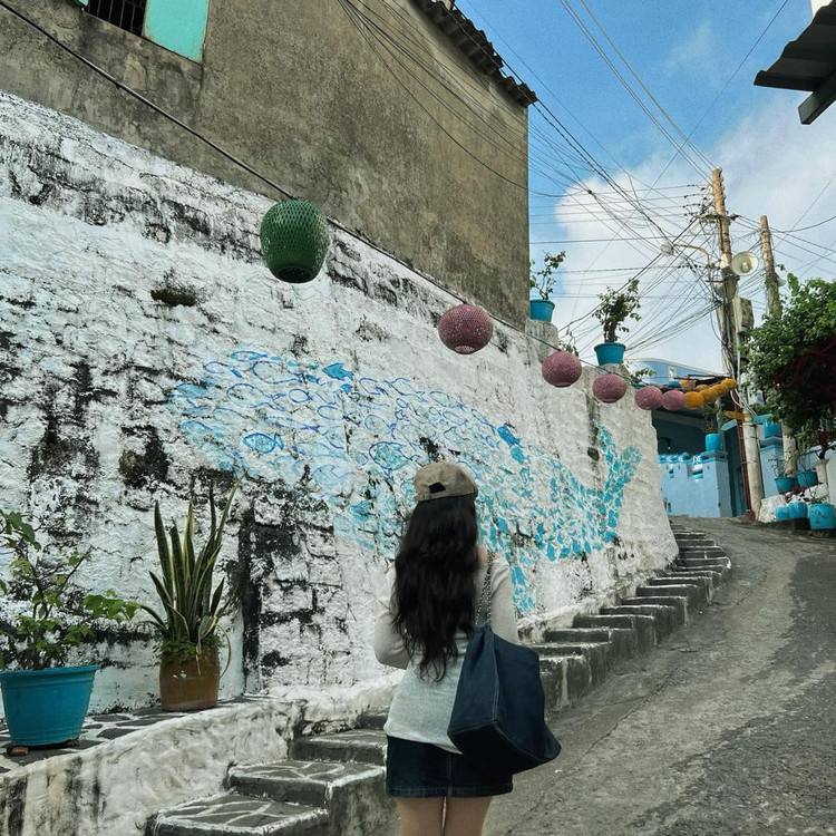 Điểm nhấn đặc biệt của Nhơn Lý chính là những bức bích họa đầy màu sắc được vẽ trên các bức tường nhà, tạo nên khung cảnh nghệ thuật độc đáo và thu hút. Với những màu sắc chủ đạo là xanh dương, trắng, vàng, những bức tranh tường này đã góp phần làm cho khung cảnh của ngôi làm thêm phần tươi vui, tràn đầy sức sống. Ảnh Vũ Thị Thu Trang