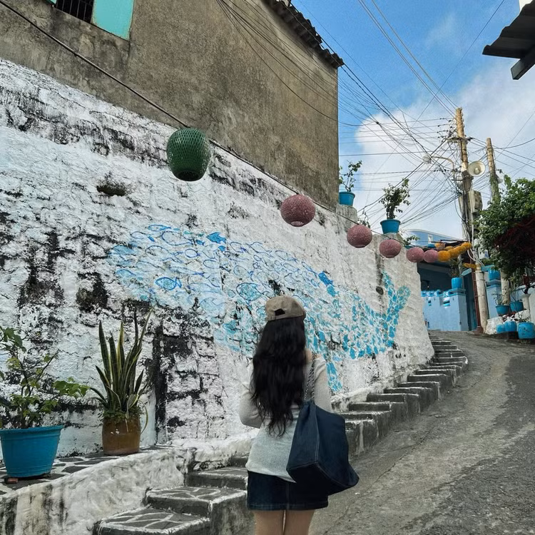 Điểm nhấn đặc biệt của Nhơn Lý chính là những bức bích họa đầy màu sắc được vẽ trên các bức tường nhà, tạo nên khung cảnh nghệ thuật độc đáo và thu hút. Với những màu sắc chủ đạo là xanh dương, trắng, vàng, những bức tranh tường này đã góp phần làm cho khung cảnh của ngôi làm thêm phần tươi vui, tràn đầy sức sống. Ảnh Vũ Thị Thu Trang