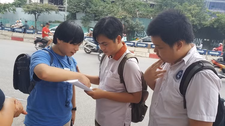 Thầy Võ Quốc Bá Cẩn đưa học sinh thi vào lớp 10 tại điểm thi Trường THPT chuyên Amsterdam, Hà Nội, chờ các em kết thúc môn thi rồi cùng học trò rà lại đáp án - Ảnh: Mai Nguyễn.