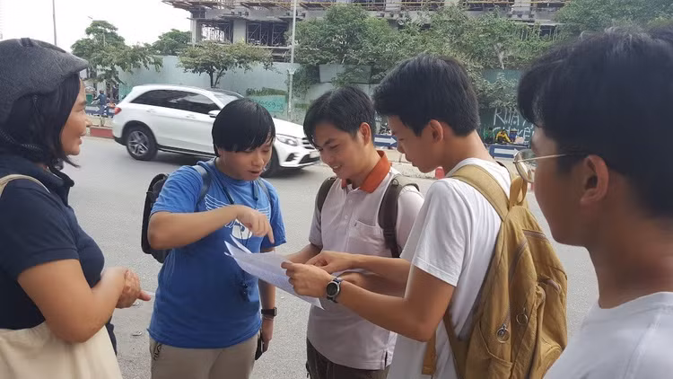 Thầy Võ Quốc Bá Cẩn đưa học sinh thi vào lớp 10 tại điểm thi Trường THPT chuyên Amsterdam, Hà Nội, chờ các em kết thúc môn thi rồi cùng học trò rà lại đáp án - Ảnh: Mai Nguyễn.