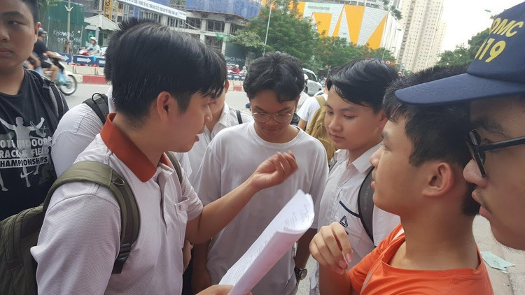 Thầy Võ Quốc Bá Cẩn đưa học sinh thi vào lớp 10 tại điểm thi Trường THPT chuyên Amsterdam, Hà Nội, chờ các em kết thúc môn thi rồi cùng học trò rà lại đáp án - Ảnh: Mai Nguyễn.