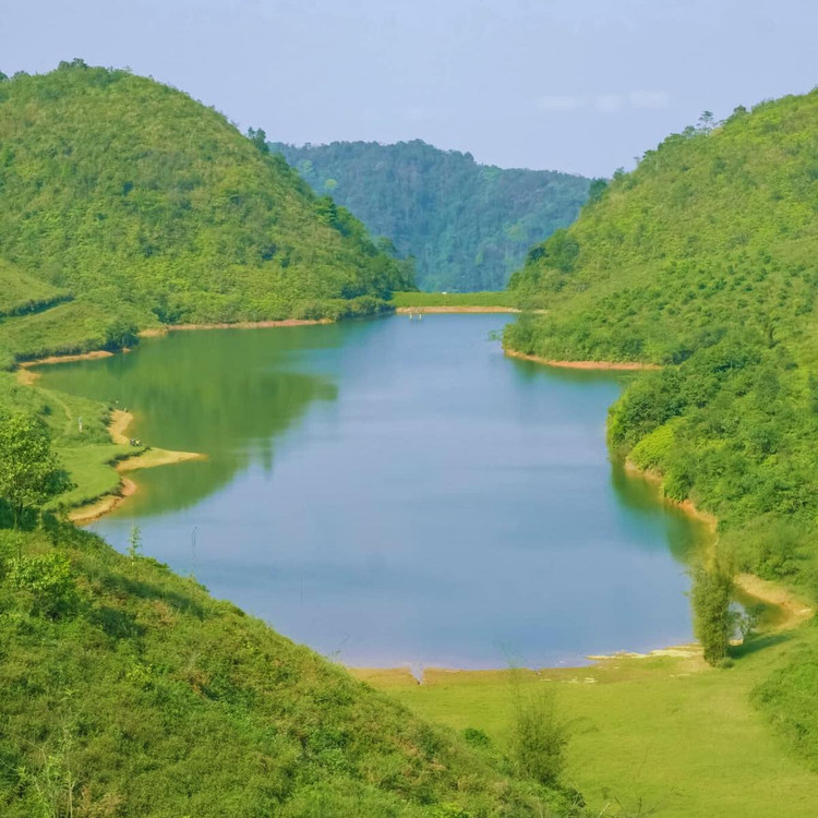 Hồ được bao bọc bởi những dãy núi đá vôi hùng vĩ. Mặt hồ phẳng lặng, trong xanh, soi bóng những ngọn núi và những hàng cây xanh rì. Ảnh Chu Đức Giang